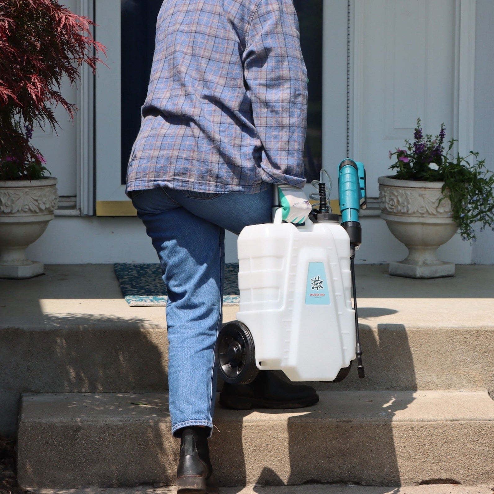 person carrying 4 gallon battery sprayer up set of stairs