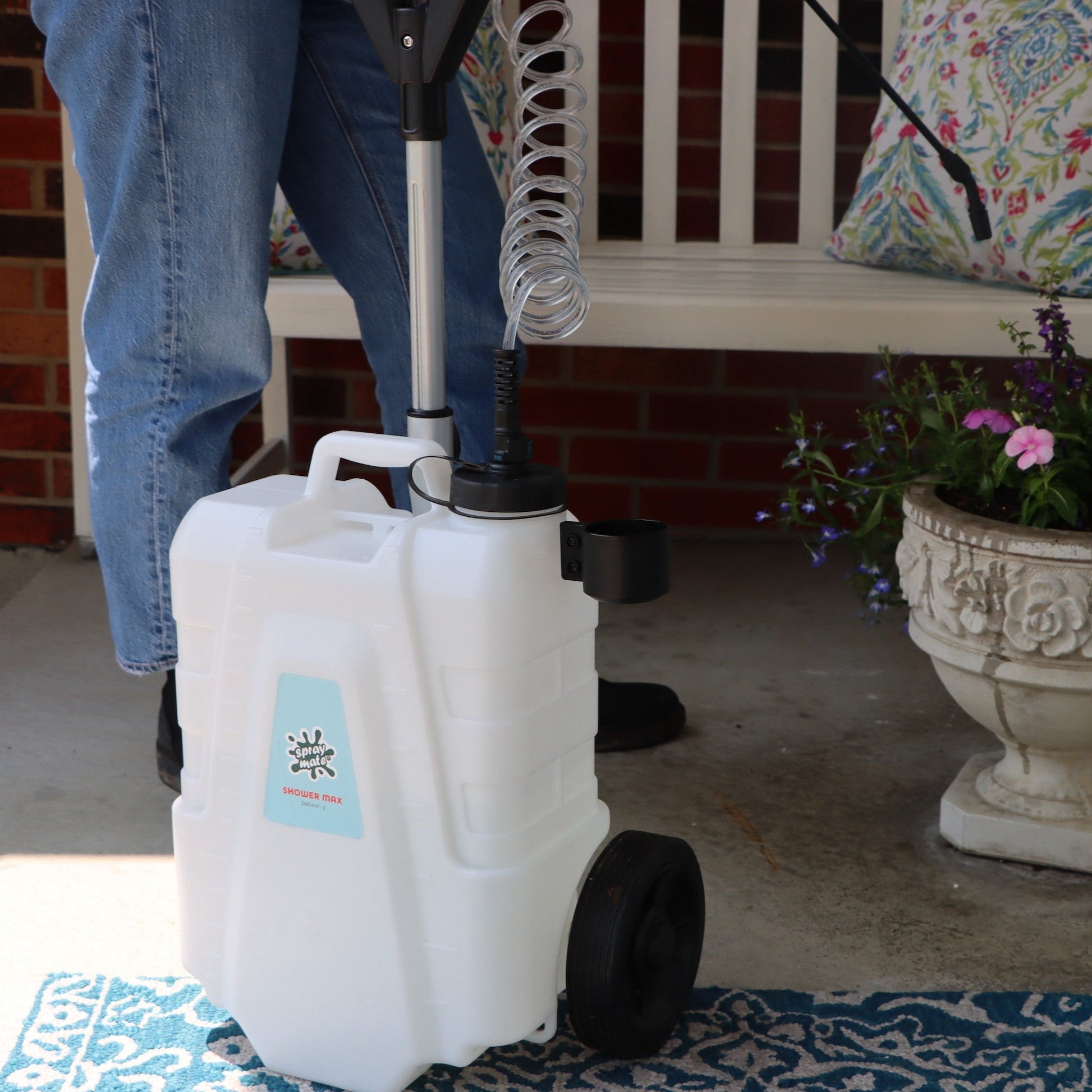 4 gallon rolling sprayer in front of flower planter