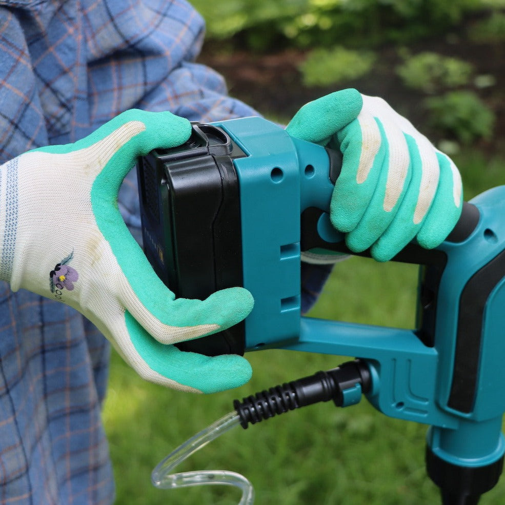 gloved hands inserting battery pack into spray gun